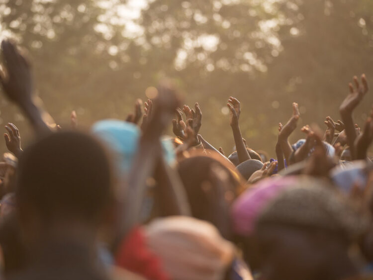 black congregation worshipping outdoors